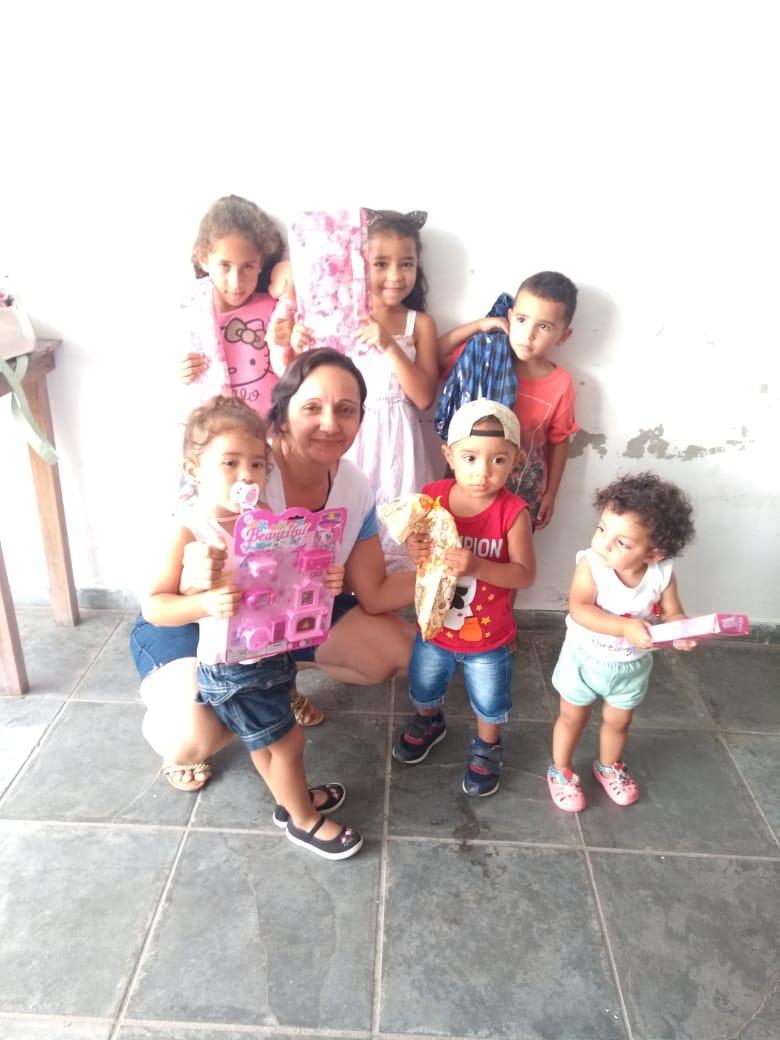 Crianças recebendo presentes em ação solidária
