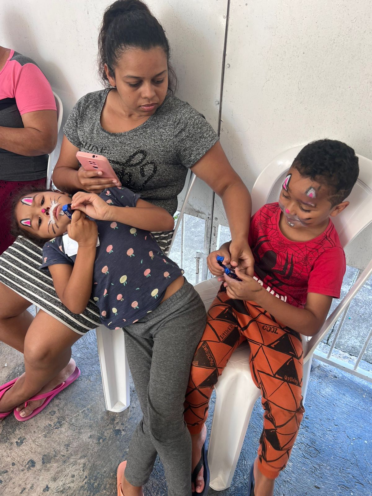 Crianças com pintura facial acompanhadas por familiar