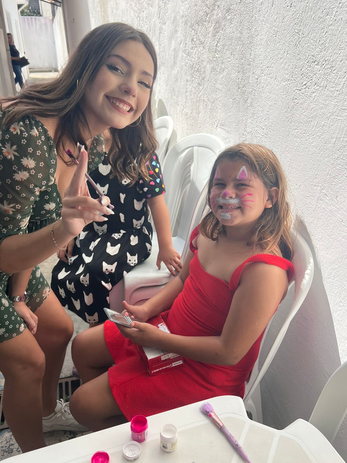 Voluntária realizando pintura facial em criança