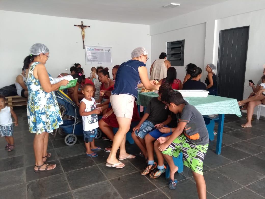 Famílias e voluntárias em encontro comunitário